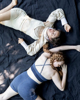 two models each wearing white and blue bralettes and bloomers